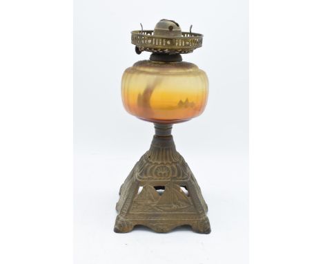An early 20th century oil lamp with a cast iron base depicting sailing scenes. 32cm tall. In good condition though untested. 