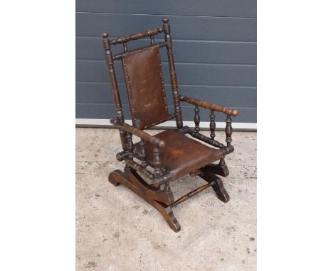 An early 20th century wooden childs American-style bobbin rocking armchair. 72cm tall. In good functional condition with some