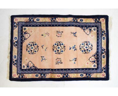 Chinese wool rug, the peach ground with flowers and foliate scroll work within Greek key border, 122cm x 182cm, together with