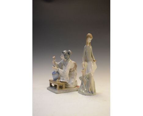 Lladro figure of a kneeling Oriental lady, together with a Nao figure of a girl holding bird, the later 26cm high  