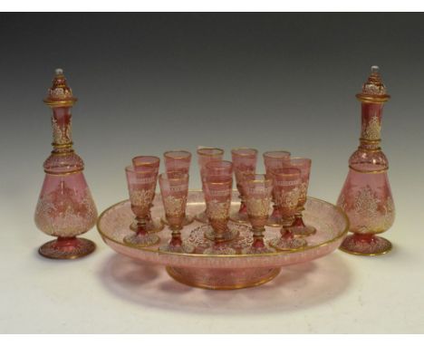 Bohemian glass suite comprising: two decanters, twelve glasses and an oval tray, all decorated with white enamel, rococo desi