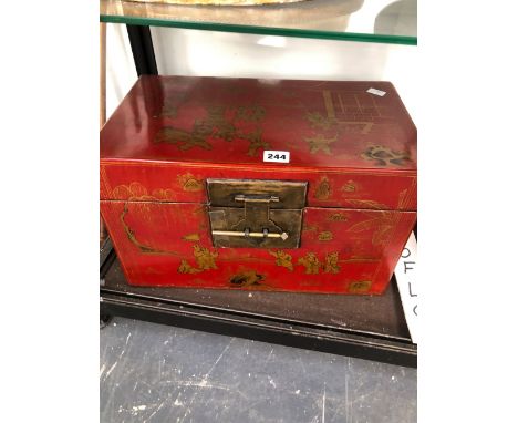 A CHINESE RED LACQUER TWO HANDLED TRUNK GILT WITH CHILDREN AT PLAY