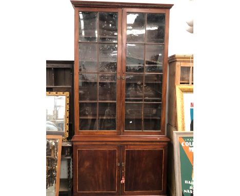 A LARGE REGENCY MAHOGANY GLAZED TOP BOOKCASE WITH PANEL DOOR BASE. H 260 x W 126 x D 47 cm