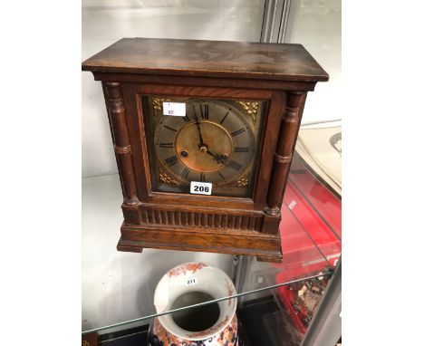AN OAK CASED MANTLE CLOCK STRIKING ON A COILED ROD