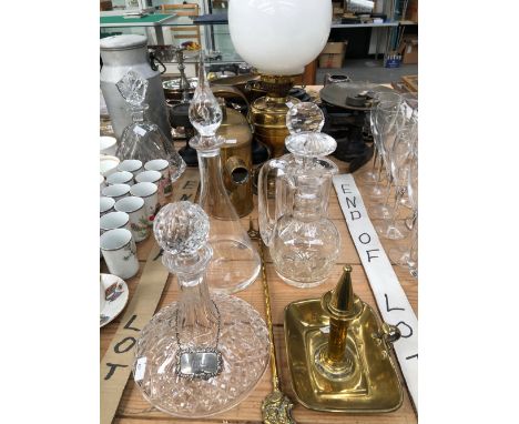 A BRASS OIL LAMP, A BRASS HOT WATER CAN, A CHAMBERSTICKS, TWO KITCHEN SCALES AND FOUR DECANTERS.