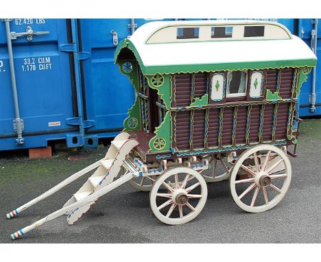 A very well made model of a approximately quarter scale travelling caravan, finished in cream, green and maroon, with nicely 