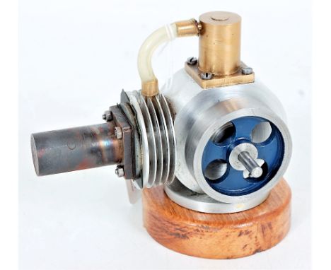 A miniature Scratchbuilt hot air engine, of usual specification, raised on wooden plinth, with un spoked fly wheel, free runn