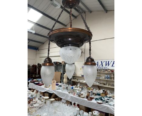 An Arts and Crafts style pendant ceiling light fitting with copper colour fittings, central cut glass dome and 3 drop lights 