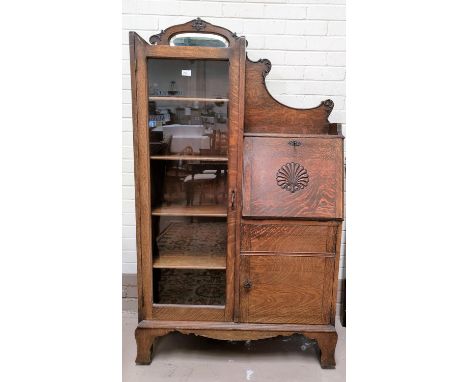 A 1930's oak side by side display cabinet with full length glazed door, cupboard and fall front writing shelf, width 94 cm 