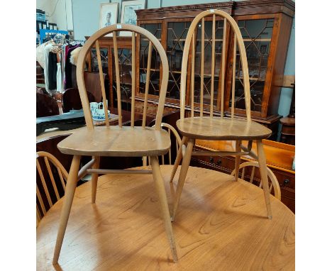 An Ercol pair of dining chairs in lightwood and elm, with stick backs; a modern set of 4 ladder back dining chairs 