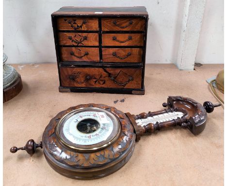 A miniature jewellery cabinet in Japanese lacquer and parquetry; an aneroid barometer with thermometer in carved walnut case 