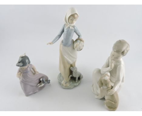 A Lladro figure, young boy with his dog, H. 20cm, together with two Nao figures of young girls with their dogs, (3)