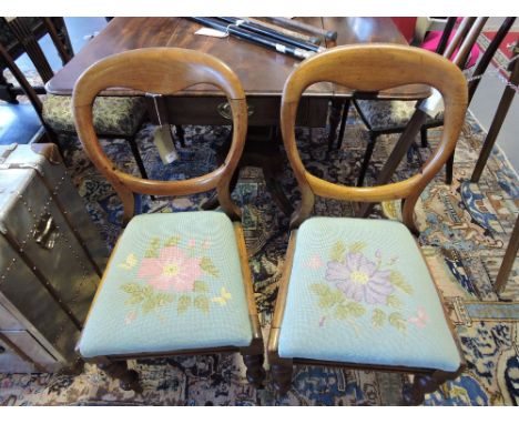 A set of four early Victorian mahogany balloon backed chairs, with tapestry Trafalgar seats, on turned legs.