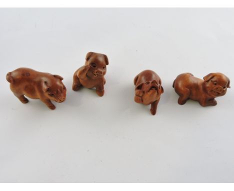 A carved hardwood netsuke in the form of a boar; together with three further hardwood netsuke carved as sow. (4)