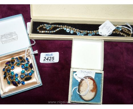 A 16" green and pearl stone necklace with earrings, a large blue and mauve stone brooch and a silver cameo brooch (all boxed)