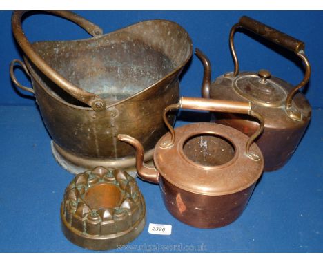 Two copper kettles, a jelly mould and a brass helmet coal bucket.