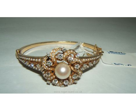 A vintage continental 14kt Seed Pearl and Diamond open flower Bangle with large central pearl 19.10mm, 1 1/2 cts of VS2 colou