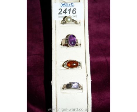 A Silver Ring set with purple stone, silver ring with amber stone, silver ring with pearl and a silver ring with purple stone