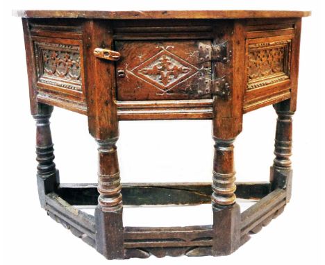 A 3' 2" late 17th Century oak credence table with flanking carved panels to canted sides and central cupboard, set on ring tu