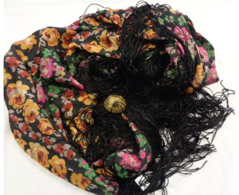 An old floral print silk shawl with fringed edge and large ornate enamelled gilt brass clasp