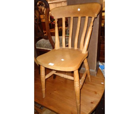 A set of four modern blonde wood Windsor style kitchen chairs with solid sectional seats, set on ring turned supports