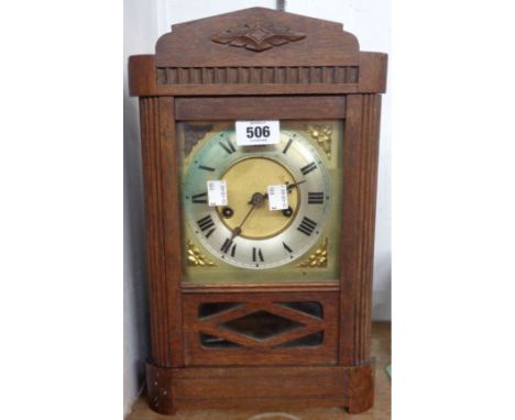 An early 20th Century oak cased shelf clock with brass and silvered dial, visible pendulum and eight day gong striking moveme