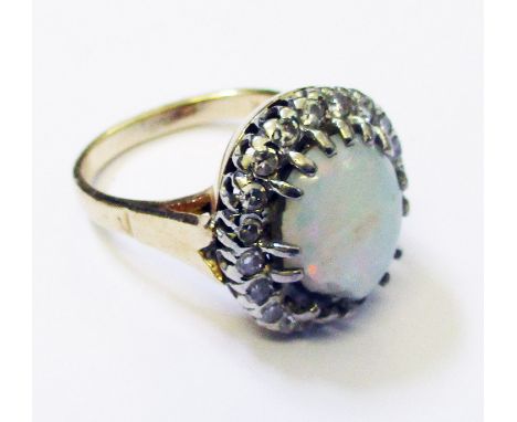 A marked 14k yellow metal ring set with damaged central opal within a diamond encrusted border (American)