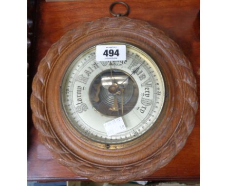 An early 20th Century Paragon oak framed sedan style wall barometer with rope twist border and visible aneroid works - glass 