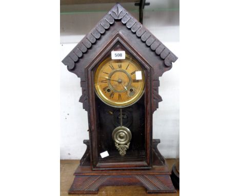 A late 19th Century American stained wood cased shelf clock of architectural design with visible pendulum and Ansonia spring 