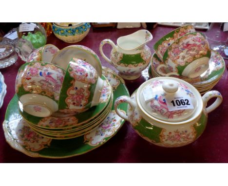 A Minton Cockatrice pattern six place part tea set, comprising six trios, bread plate, milk jug and lidded sucrier 