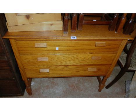 A 36" vintage polished oak chest of three long graduated drawers, set on a bobbin turned open stretcher base