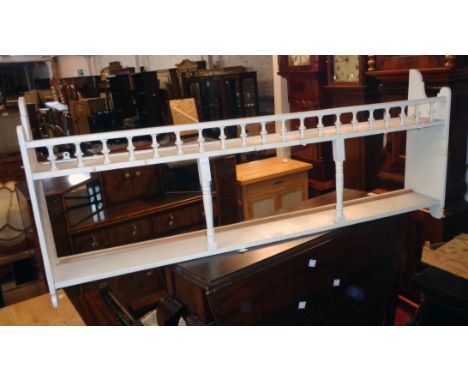 A 3' 6" painted wood wall mounted plate rack shelf with spindle decoration and shaped sides