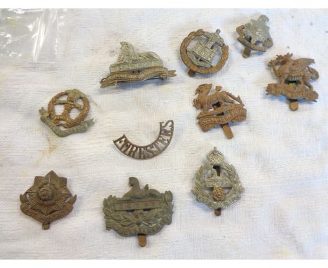 A collection of British Army infantry cap badges including Royal Berkshire Regiment, The Buffs, Royal Gloucestershire Regimen