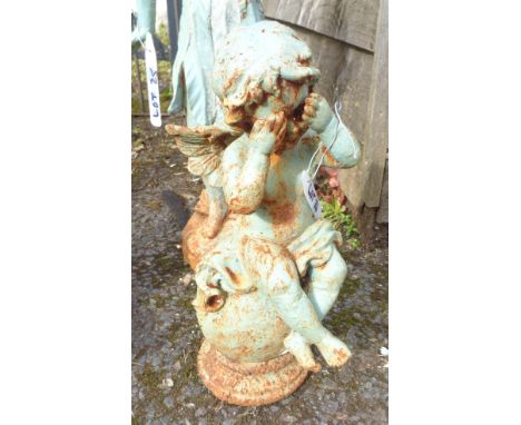 A cast iron garden angel seated on a ball