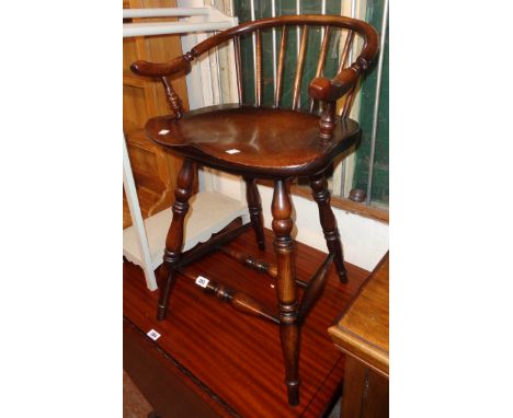 A reproduction stick back bow elbow chair with moulded solid elm seat, set on turned supports