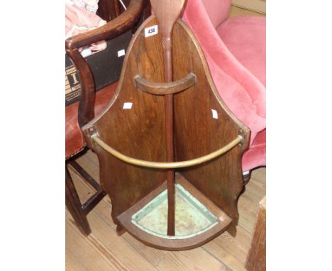 An early 20th Century stained oak corner stick stand with brass rail and drip tray