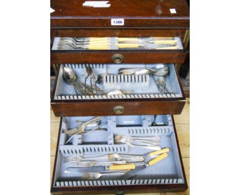 An early 20th Century oak drawer fitted canteen by Evans &amp; Matthews, with associated silver plated cutlery part contents