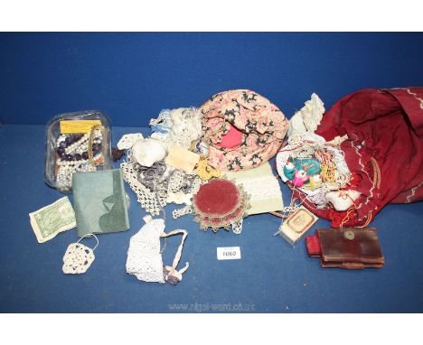 A quantity of needlework items including lace, Mother of Pearl buttons, leather sewing case, etc plus necklaces, dollar bill 
