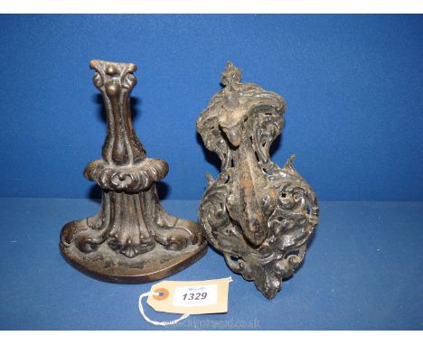 A cast iron door knocker having a peacock head and a cast iron door stop.