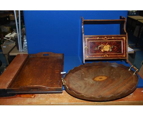 A wall mounted cupboard with shelf above with detail of musical instruments and ribbons, an oval tray with wavy edges, brass 