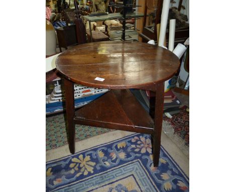 An Oak three plank top Cricket Table, the legs united by a triangular lower shelf, 26 3/8'' diameter x 27 3/8'' high