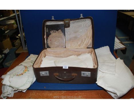 An old vanity suitcase and contents of vintage linen including embroidered, lace edged etc.