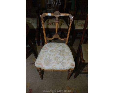 A stylised light and dark stained Beech wood side Chair standing on turned and fluted front legs and having a pale cream grou