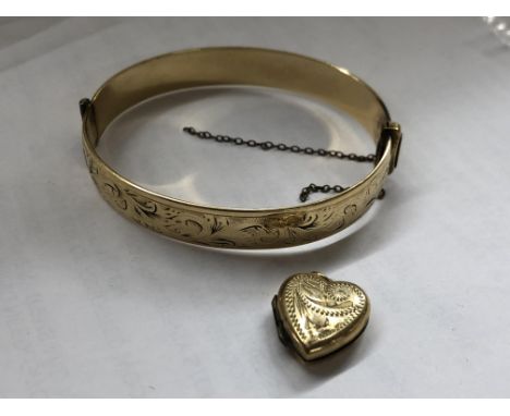 ROLLED GOLD HEART SHAPED LOCKET AND A 9CT METAL CORE ENGRAVED BANGLE 
