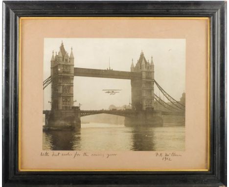 An early 20th century photograph of a hydroplane flying though Tower Bridge, circa 1912:,  mounted and inscribed 'With Best W