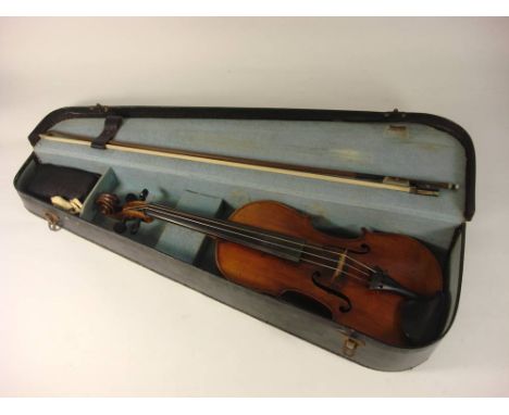 A Czechoslovakian violin: scroll carved headstock over ebony finger board and body with two piece back, bears Stradivarius la