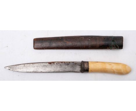 A Burmese dha dagger: the short blade over a white metal hilt and one piece ivory grip, in a wooden scabbard. blade length, 1