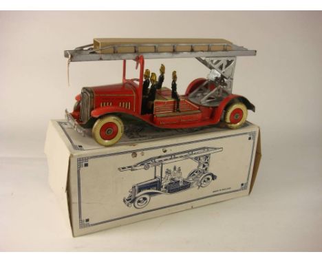 A tinplate clockwork fire engine,: with silver turntable and ladder, red lithograph printed cab, chassis, firemen and white t