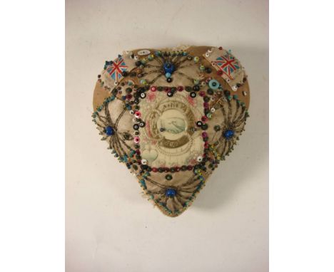 A First World war sweetheart cushion: the central celluloid panel surrounded by beaded pins and embroidery with silk flags to