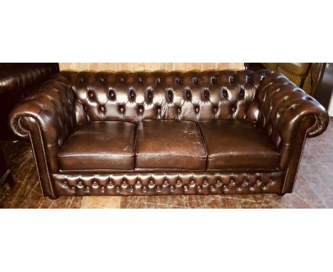 A 20th Century Chesterfield faux leather sofa, scrolling button back and arms, three cushion seats, raised on bun feet. 72cm 